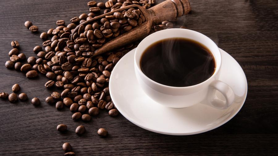 Kop koffie met bonen en schep
